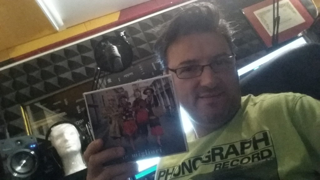selfie di Gianluca Voltolina con la copertina dell'album "Le migliori" di Mina e Celentano